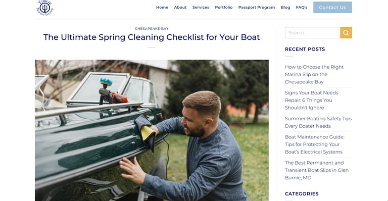 Man cleaning the exterior of a boat with a brush during spring maintenance